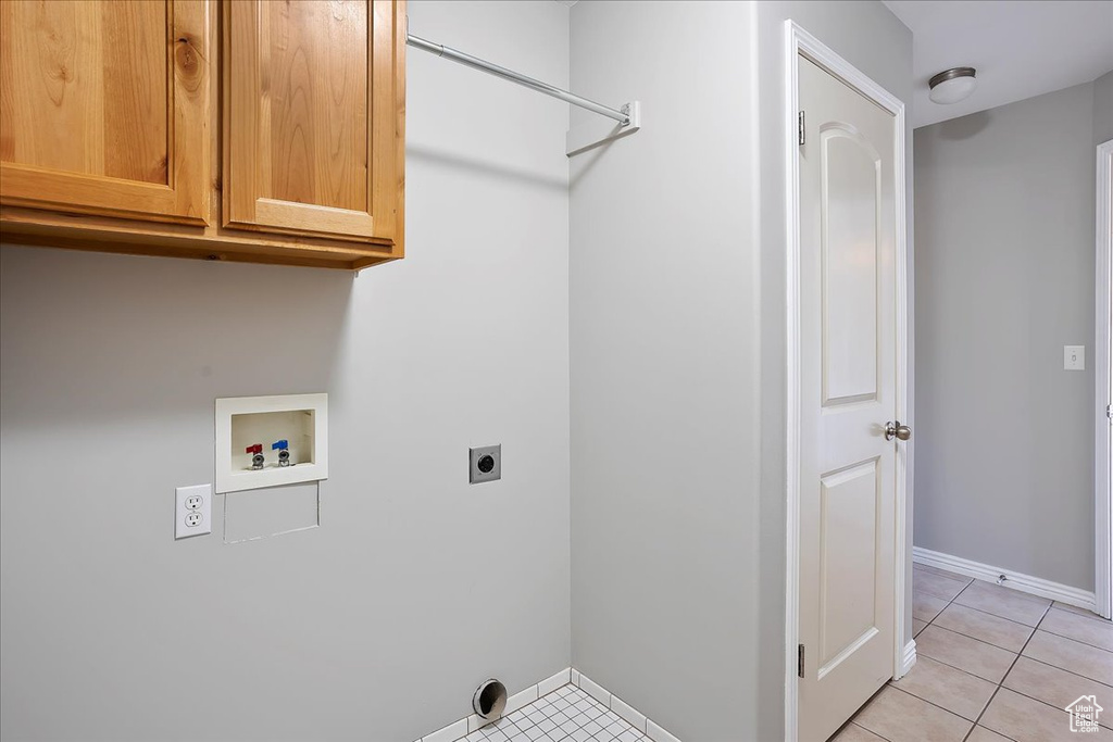 Laundry room with light tile patterned flooring, washer hookup, baseboards, cabinet space, and electric dryer hookup