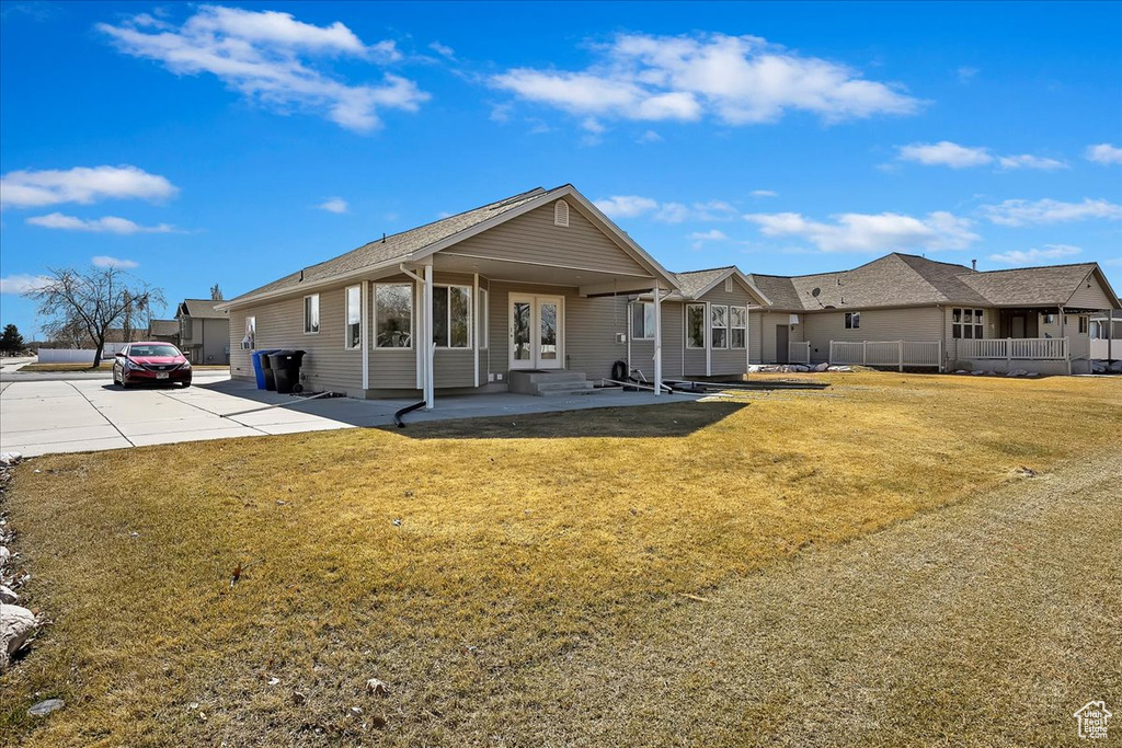 View of front of property with entry steps, french doors, and a front yard