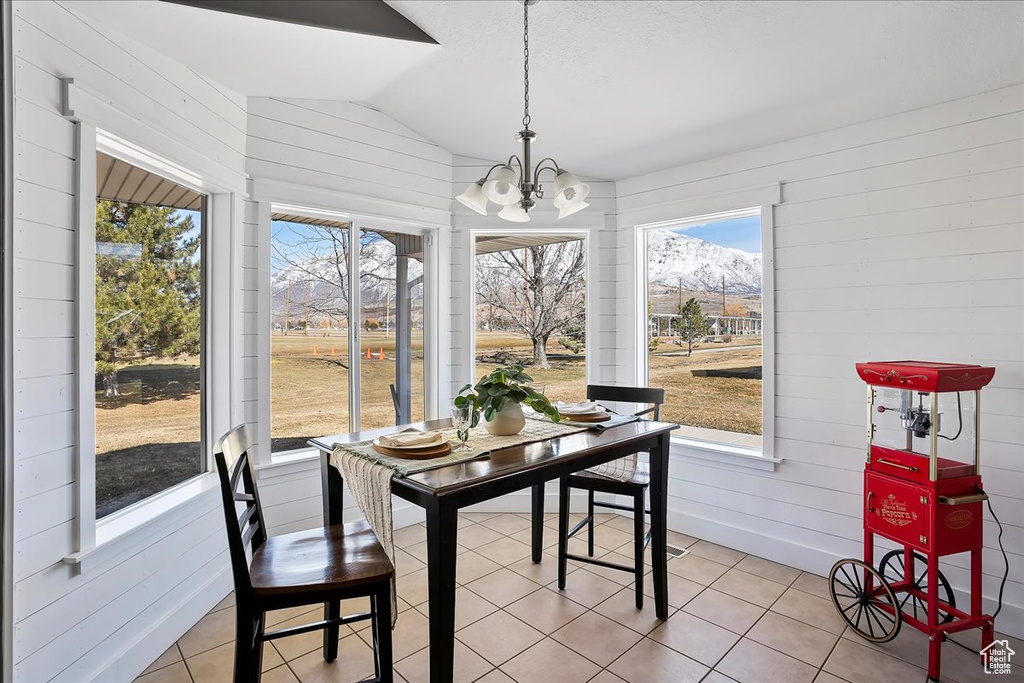 Sunroom featuring lofted ceiling and an inviting chandelier