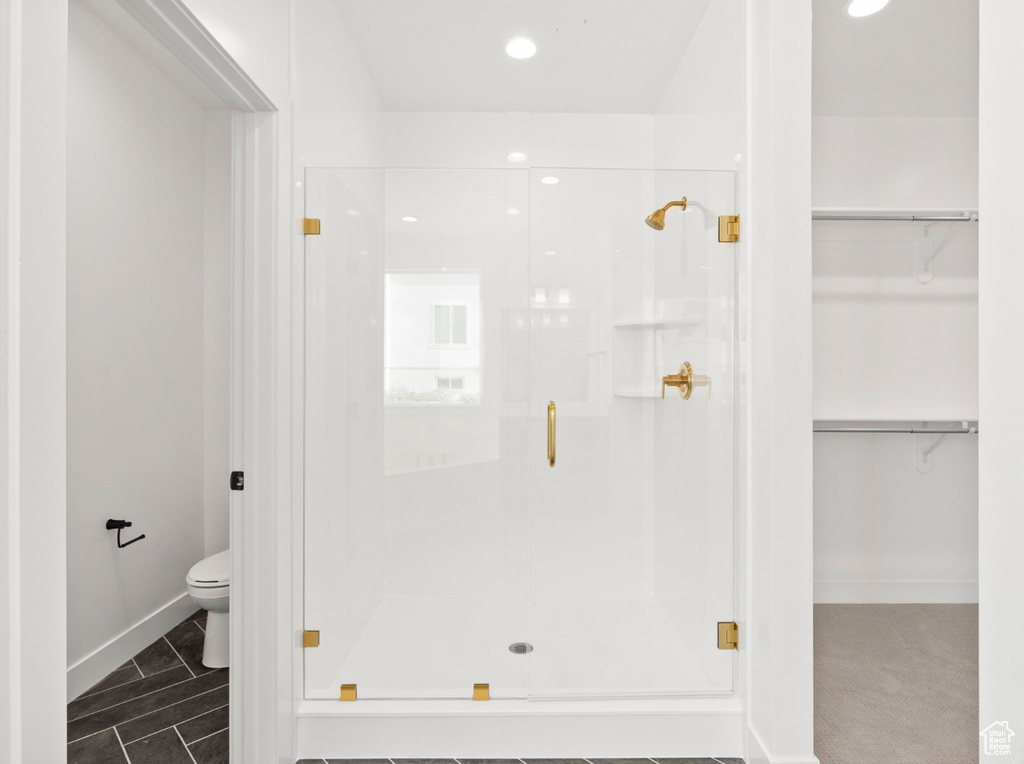 Bathroom featuring a stall shower, a walk in closet, and recessed lighting