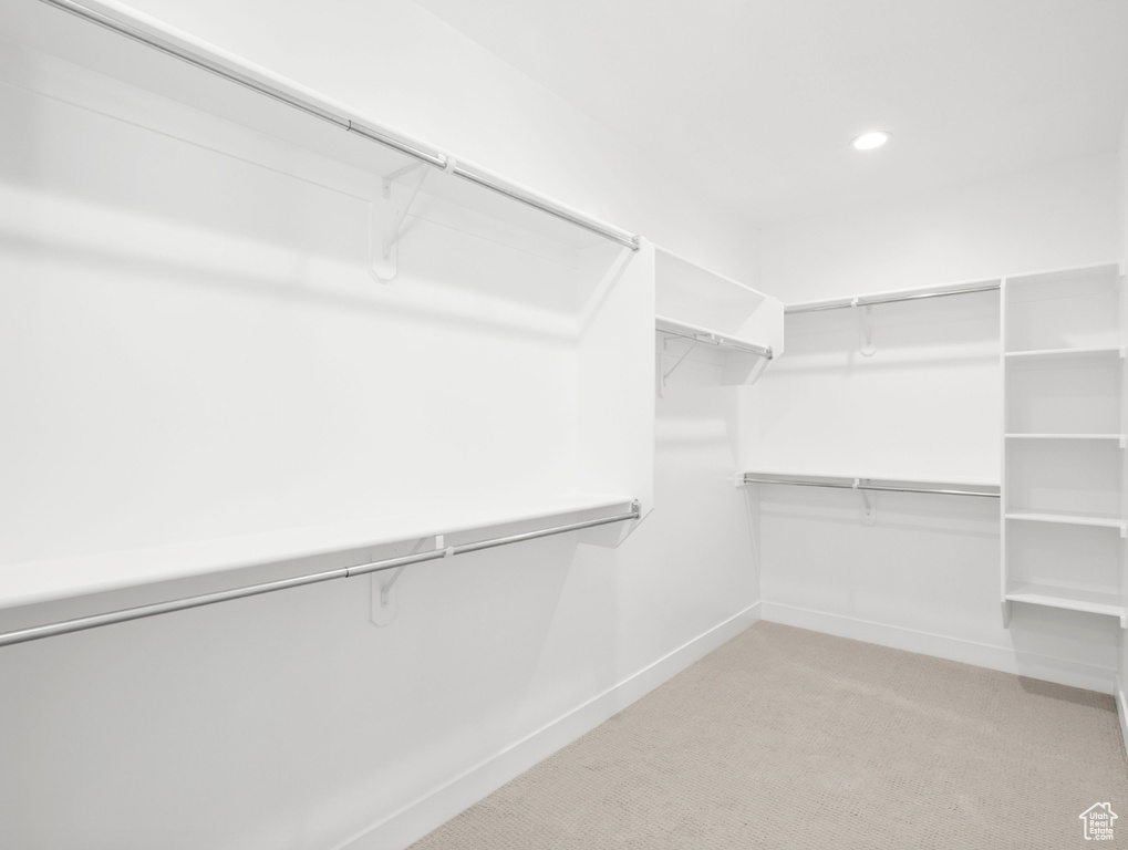 Walk in closet with light colored carpet