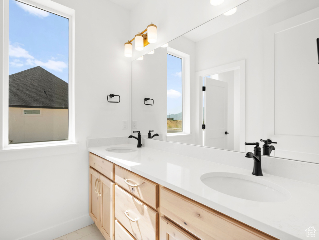 Full bath featuring double vanity and baseboards