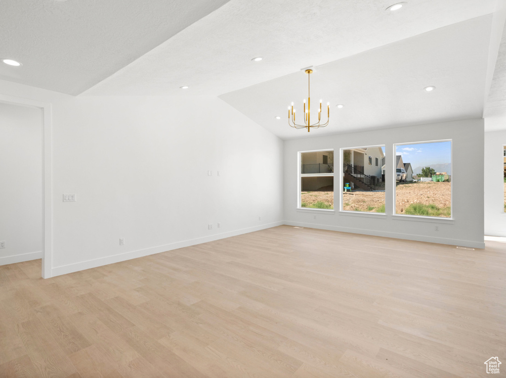 Empty room featuring a chandelier, light wood finished floors, and recessed lighting