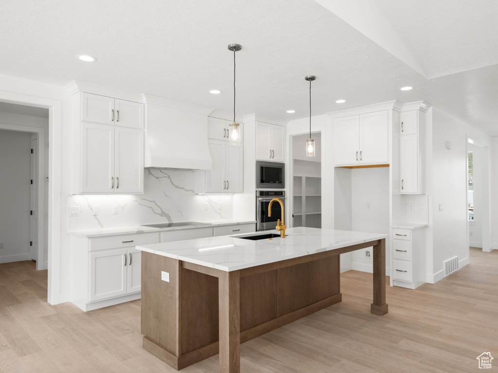 Kitchen featuring appliances with stainless steel finishes, custom range hood, recessed lighting, backsplash, and white cabinets