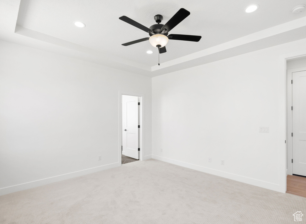 Empty room with recessed lighting, a smoke detector, light carpet, ceiling fan, and a raised ceiling