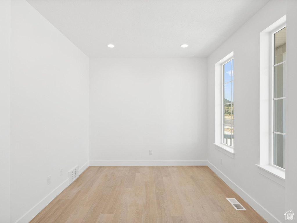 Spare room with light wood finished floors, healthy amount of natural light, and recessed lighting