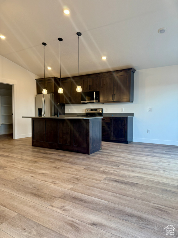 Kitchen featuring appliances with stainless steel finishes, a kitchen island with sink, light wood-style floors, and dark brown cabinets