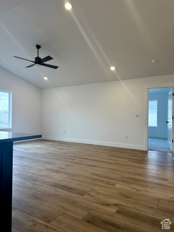 Spare room with recessed lighting, wood finished floors, a ceiling fan, baseboards, and vaulted ceiling