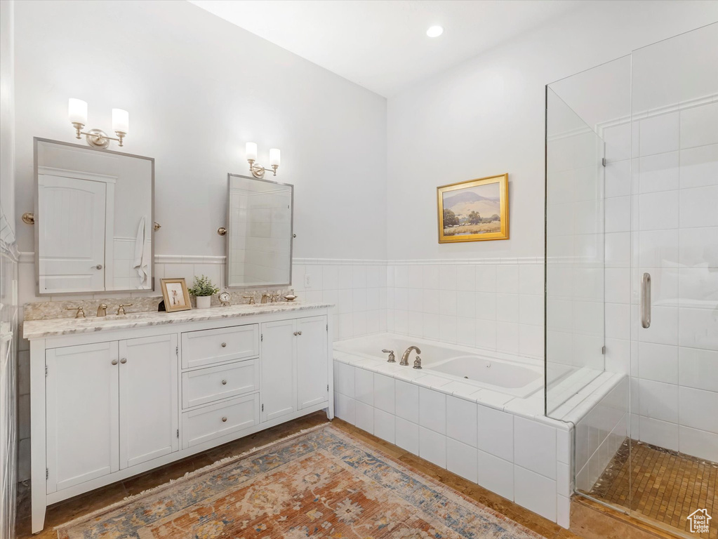 Bathroom featuring double vanity, a garden tub, and a shower stall