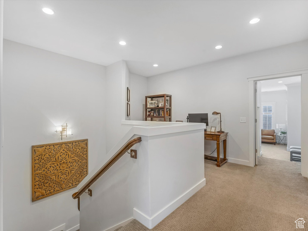 Corridor featuring light carpet, baseboards, an upstairs landing, and recessed lighting