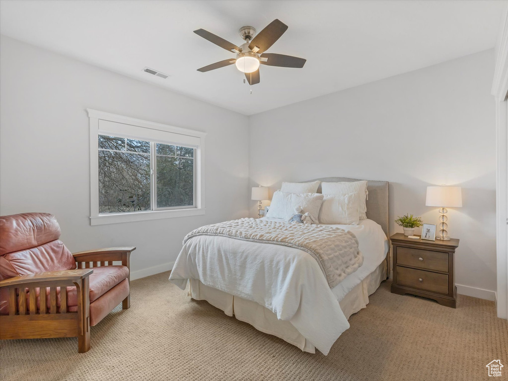 Bedroom with baseboards, ceiling fan, visible vents, and light colored carpet