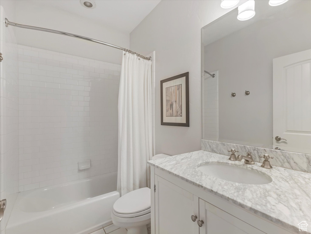 Full bathroom with vanity, tile patterned flooring, shower / bath combination with curtain, and toilet