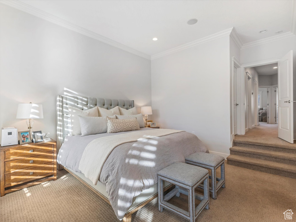 Bedroom featuring light carpet, baseboards, and crown molding