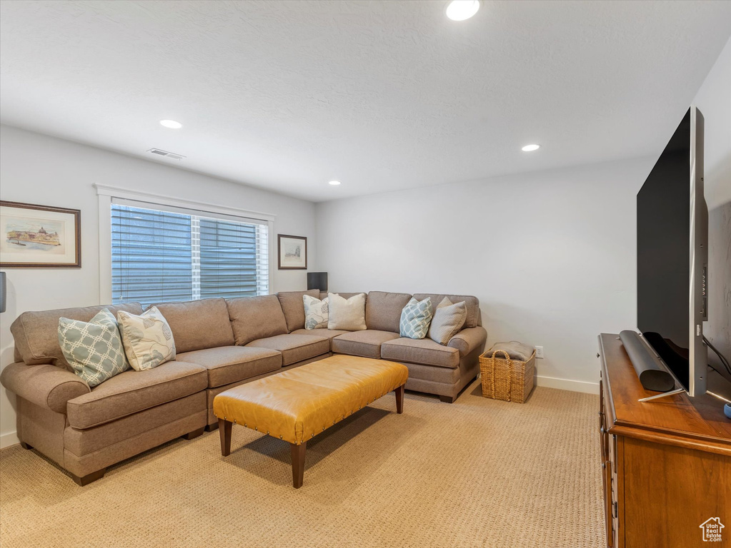 Living area with recessed lighting, visible vents, light carpet, and baseboards