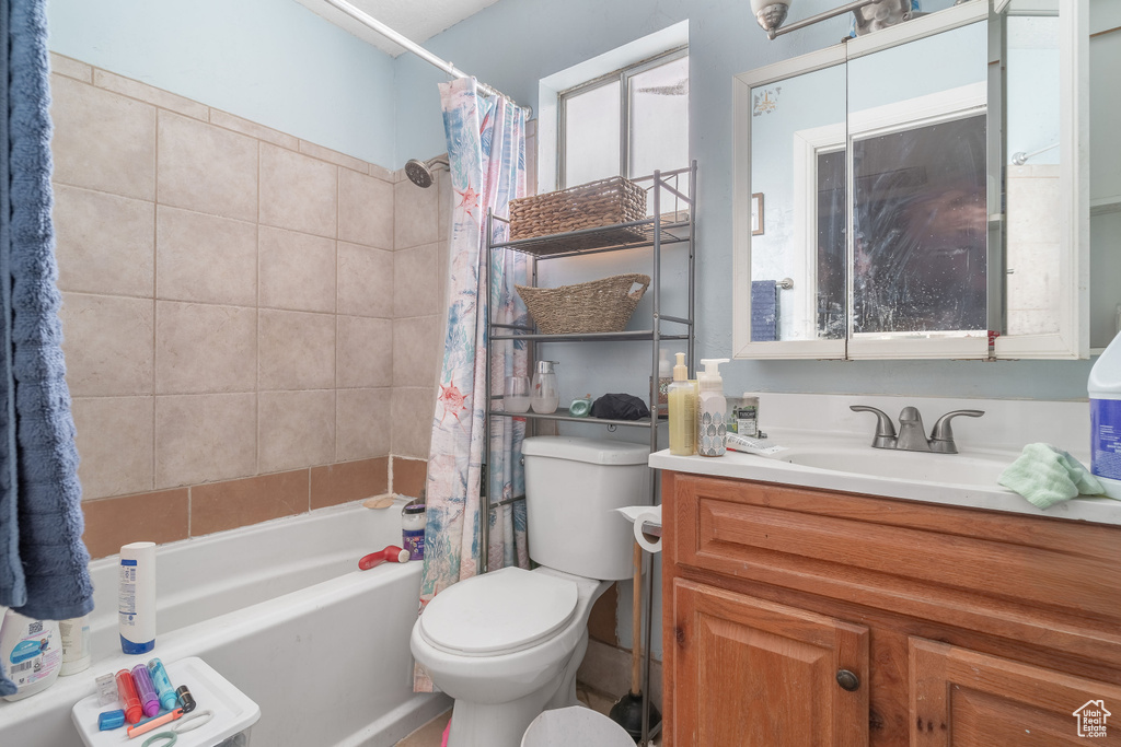 Bathroom featuring shower / bath combo, vanity, and toilet