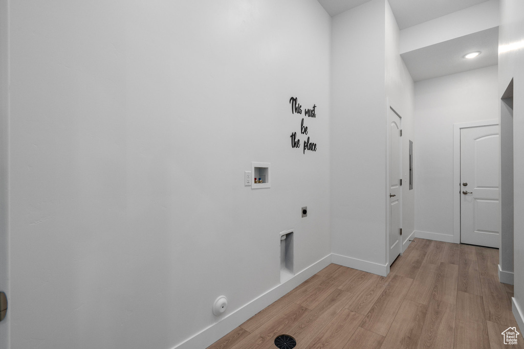 Washroom with washer hookup, light wood-style flooring, hookup for an electric dryer, gas dryer hookup, and baseboards