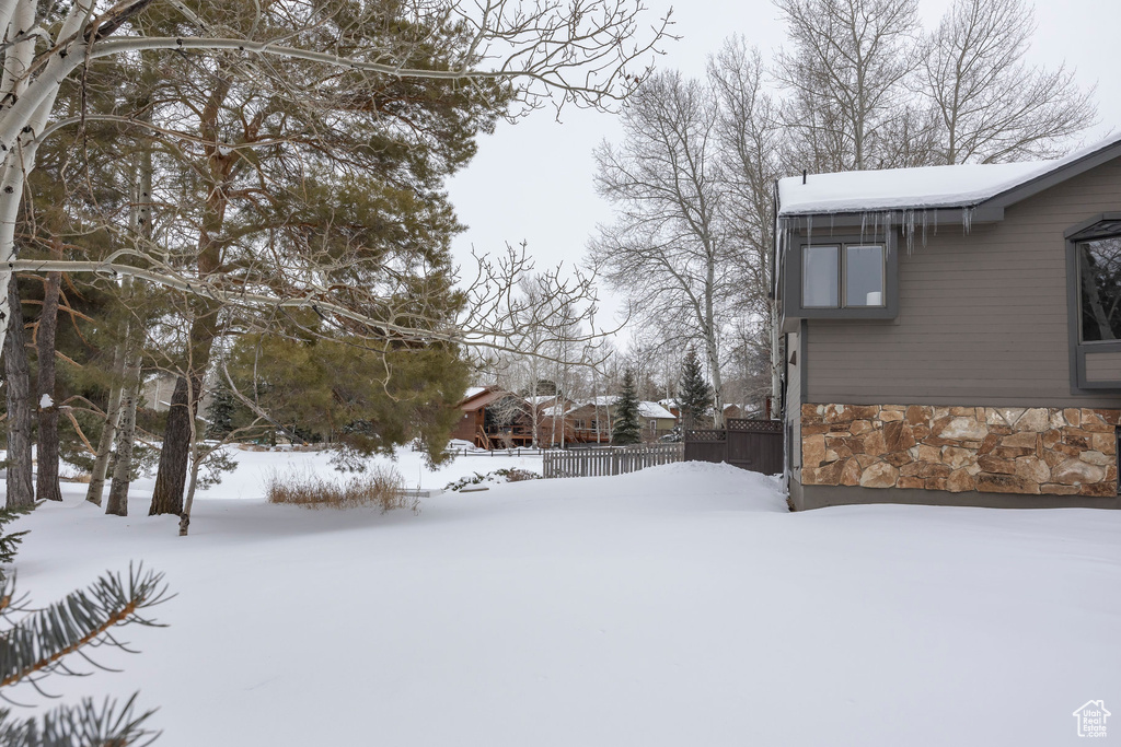 Snowy yard featuring fence