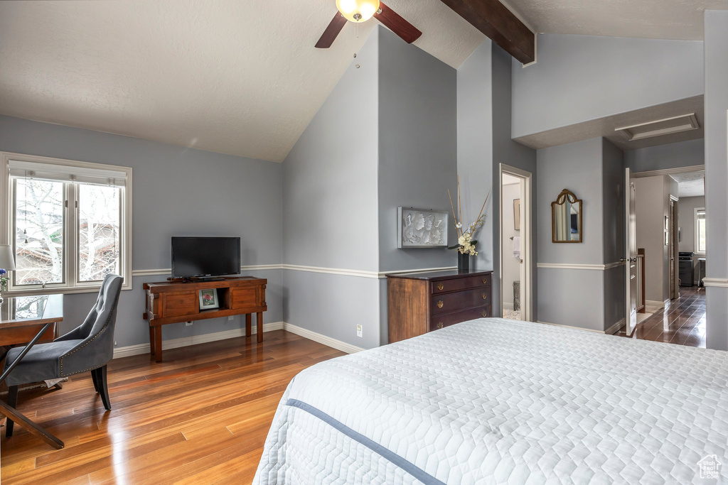 Bedroom featuring attic access, wood finished floors, baseboards, high vaulted ceiling, and beamed ceiling