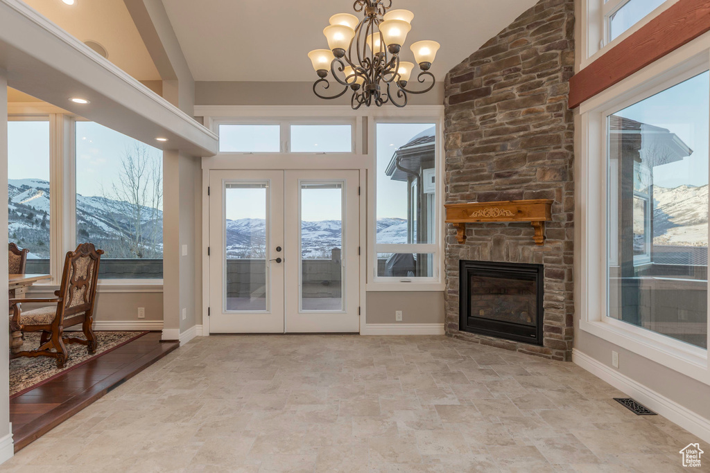 Interior space with french doors, visible vents, vaulted ceiling, a mountain view, and an inviting chandelier