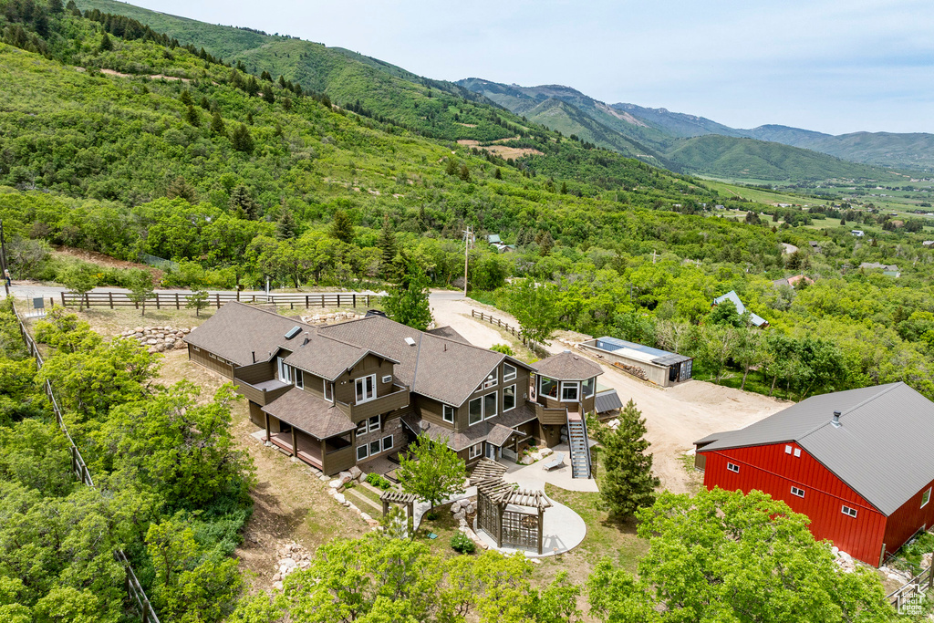 View from above of property featuring a heavily wooded area and a mountainous background
