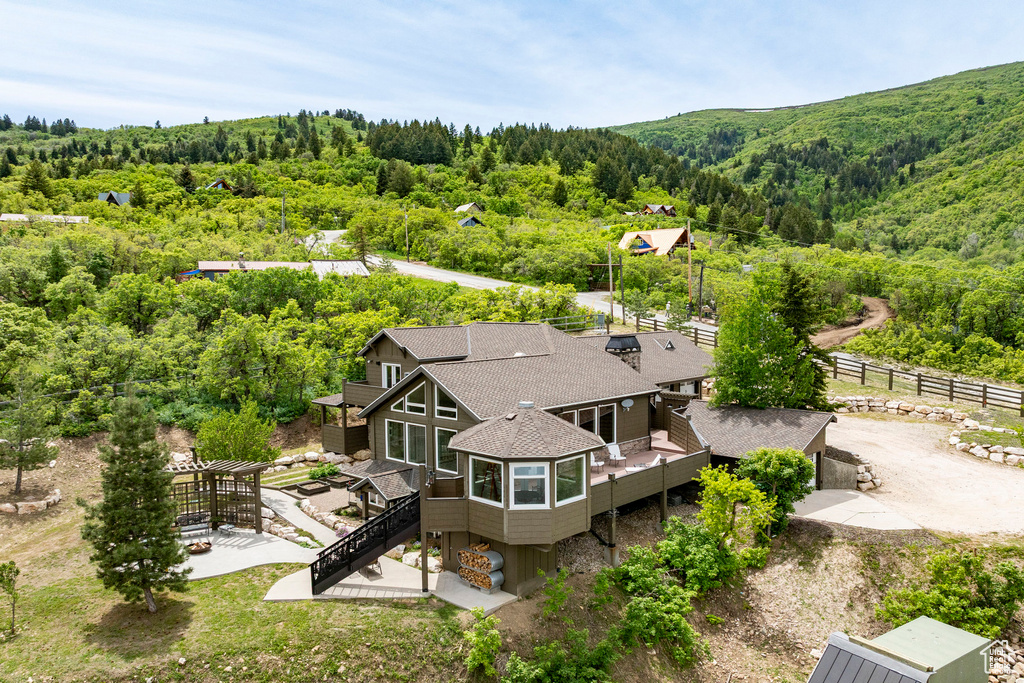Aerial view of property and surrounding area with a forest