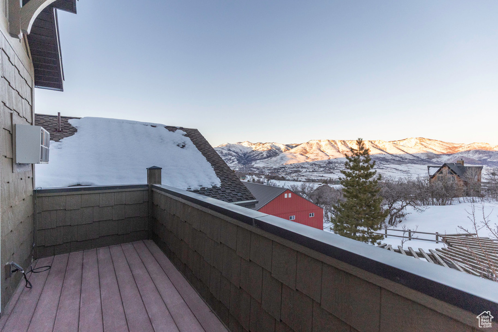 Snow covered back of property with a mountain view