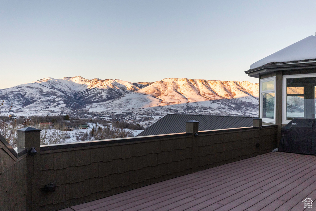Snow covered deck with a mountain view