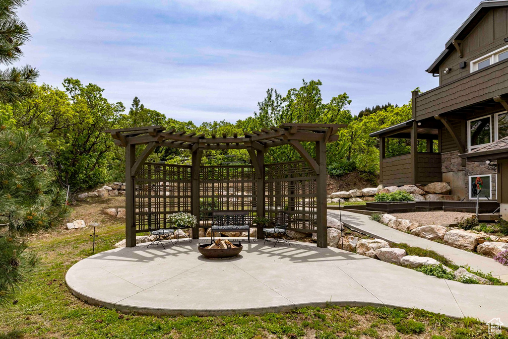 View of patio featuring a fire pit and a pergola