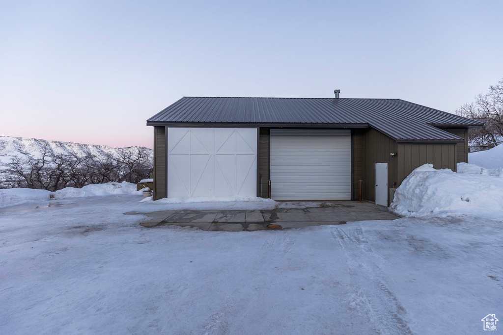 Snow covered garage with a detached garage