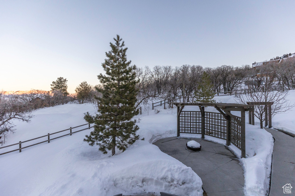 Yard layered in snow featuring fence