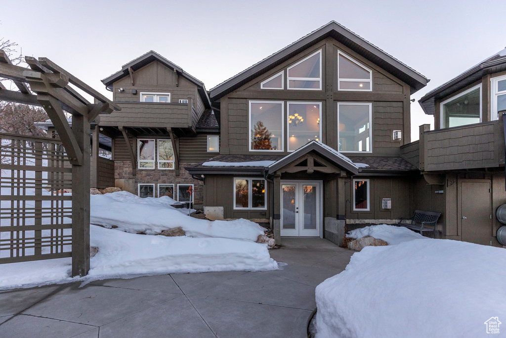 Craftsman inspired home featuring a pergola, french doors, and stone siding