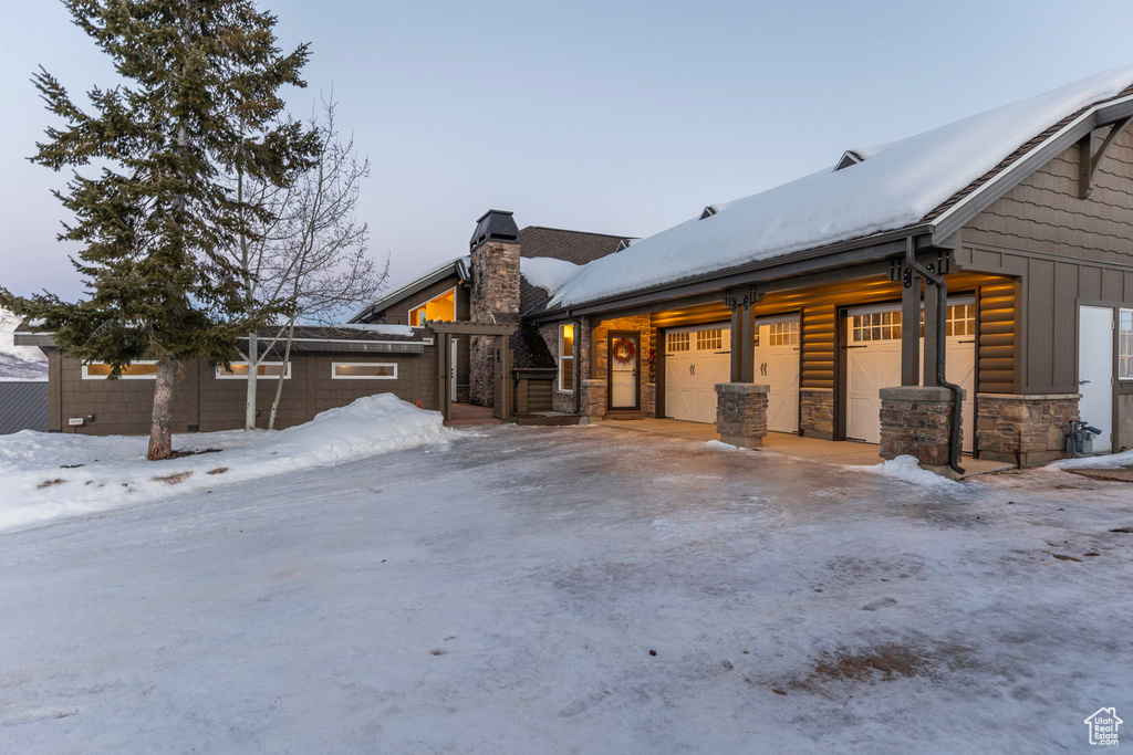 View of front of house featuring a chimney and stone siding