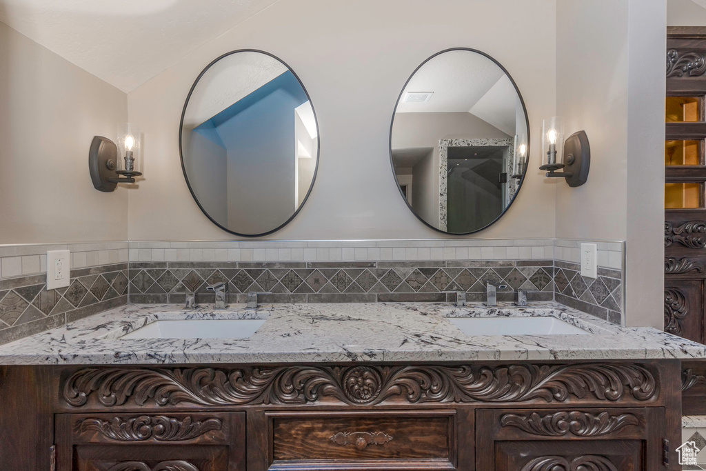Full bathroom featuring vaulted ceiling and a sink