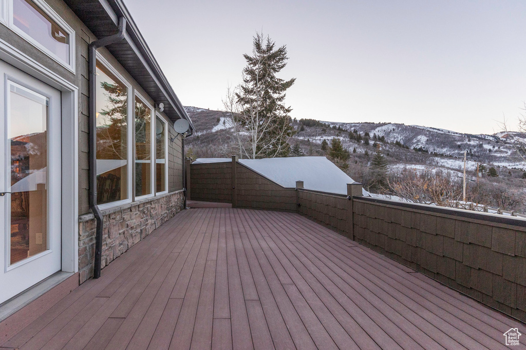 Snow covered deck featuring a mountain view