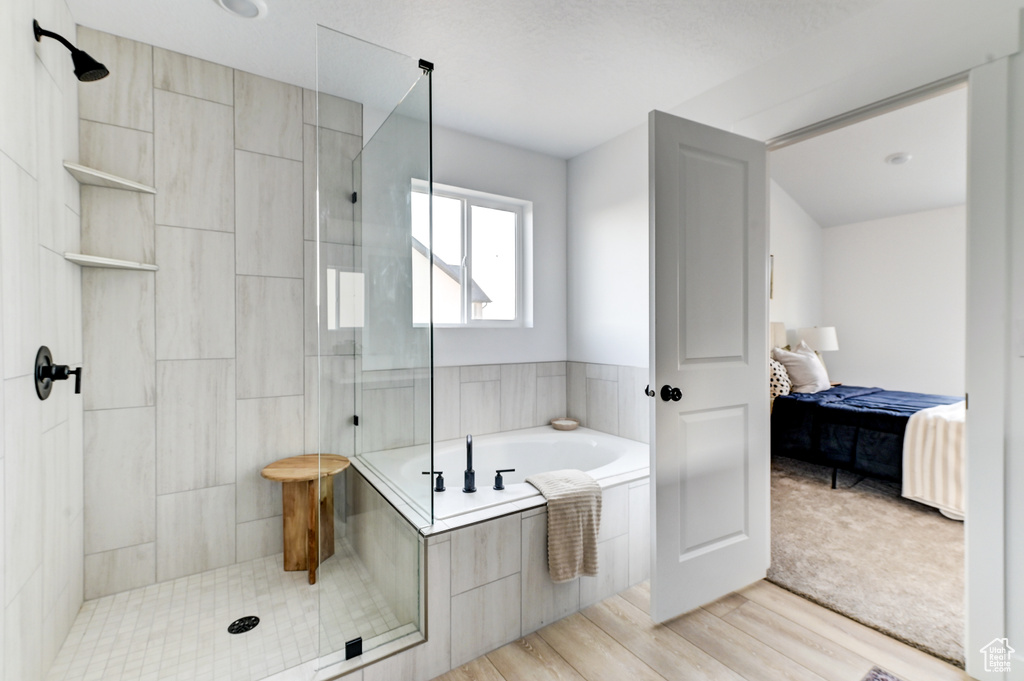 Full bathroom featuring a garden tub, tiled shower, wood finished floors, and connected bathroom