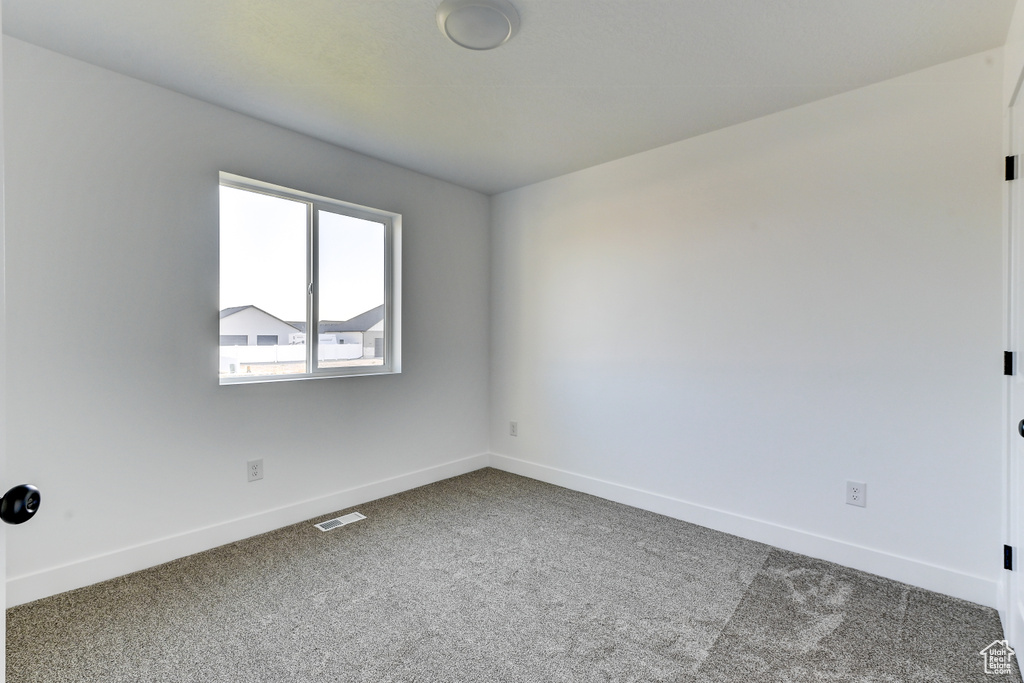 Carpeted spare room with baseboards and visible vents