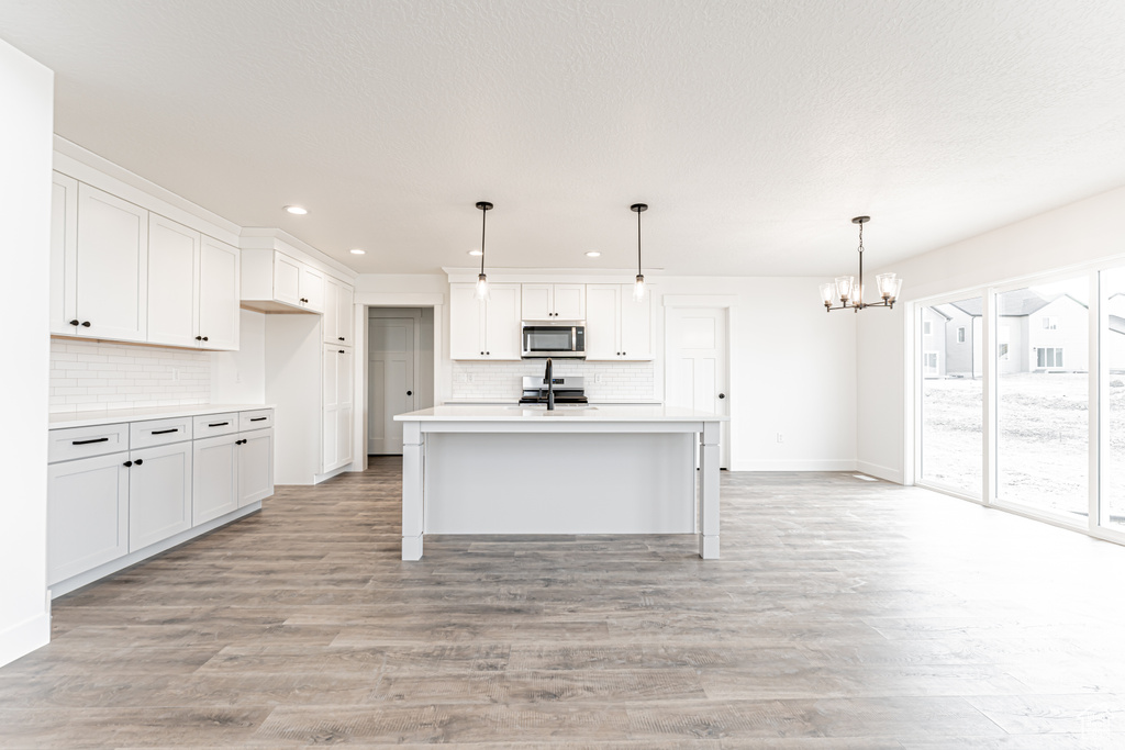 Kitchen featuring appliances with stainless steel finishes, a chandelier, backsplash, recessed lighting, and light countertops