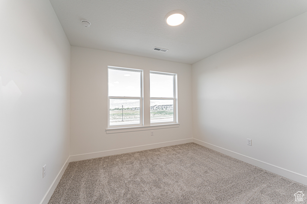 Unfurnished room with carpet, a smoke detector, and baseboards