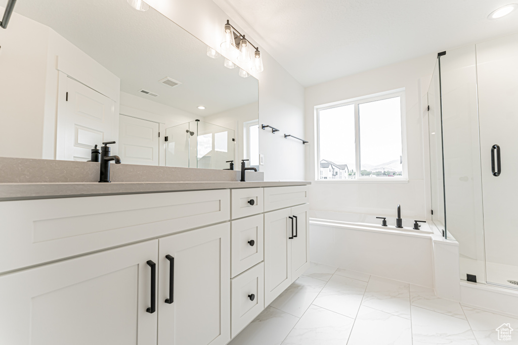 Full bathroom with double vanity, a stall shower, a bath, marble finish floors, and recessed lighting