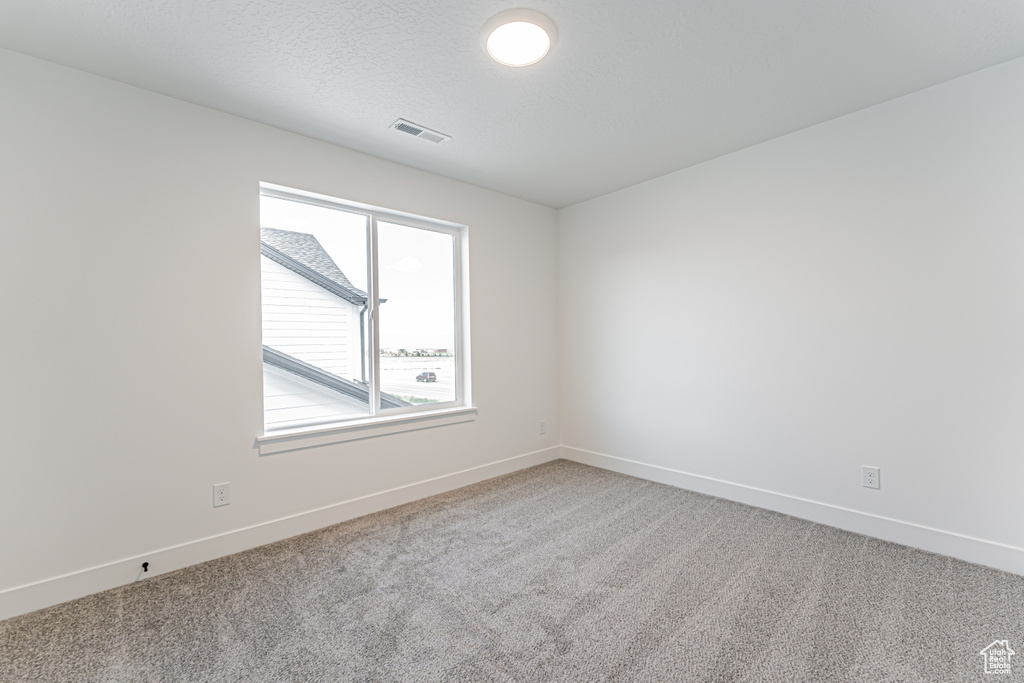 Spare room with carpet and baseboards