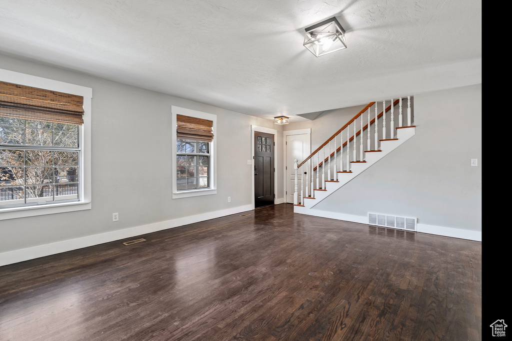 Interior space featuring a wealth of natural light, stairway, wood finished floors, and visible vents