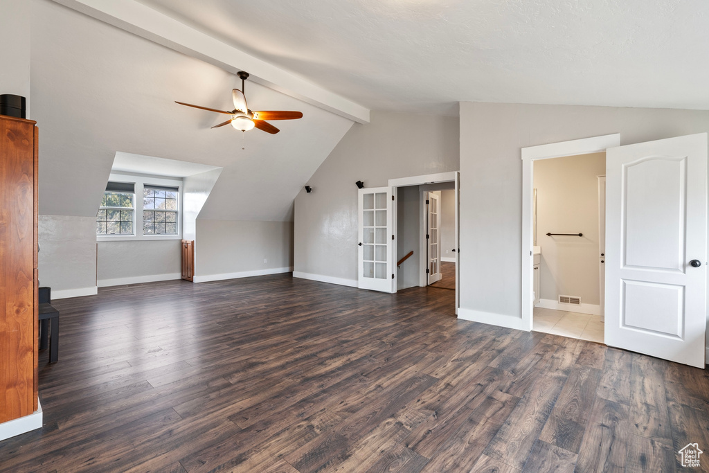 Additional living space featuring ceiling fan, vaulted ceiling with beams, baseboards, and wood finished floors