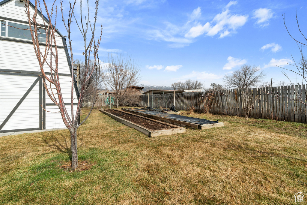 View of yard featuring a vegetable garden and fence