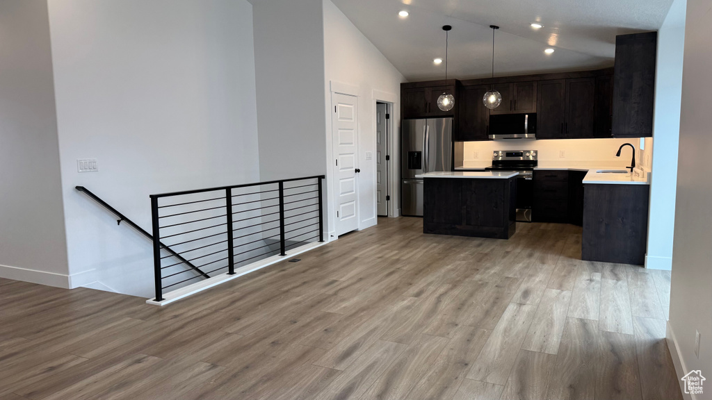 Kitchen with a center island, light countertops, light wood-type flooring, and stainless steel appliances