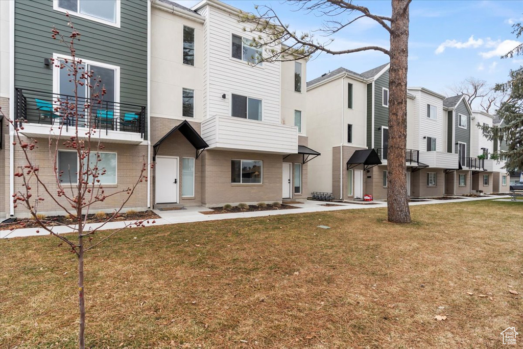 View of front facade with a residential view, a front lawn, and brick siding