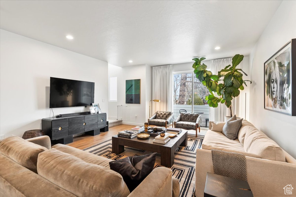 Living area with baseboards, wood finished floors, and recessed lighting