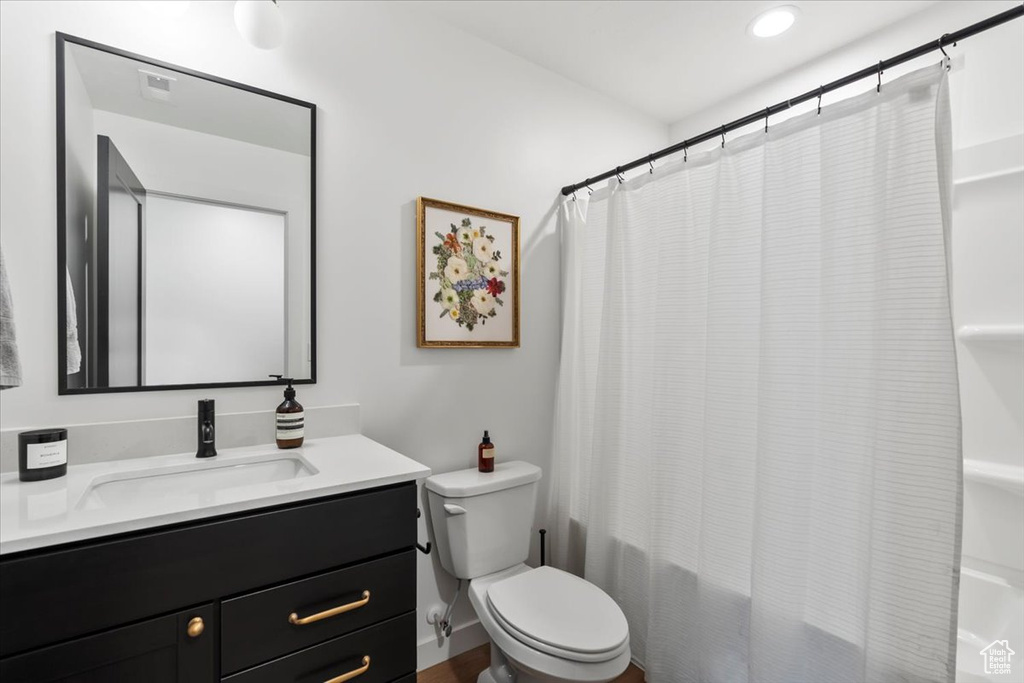 Full bathroom with toilet, shower / bath combination with curtain, and vanity