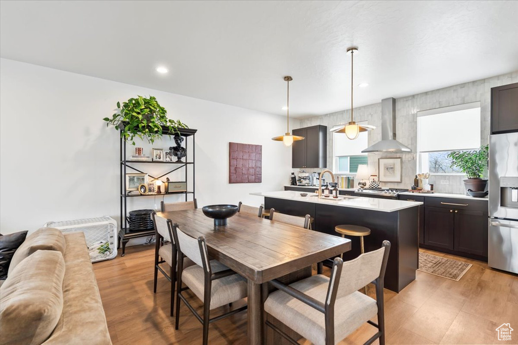 Dining area with light wood finished floors and recessed lighting