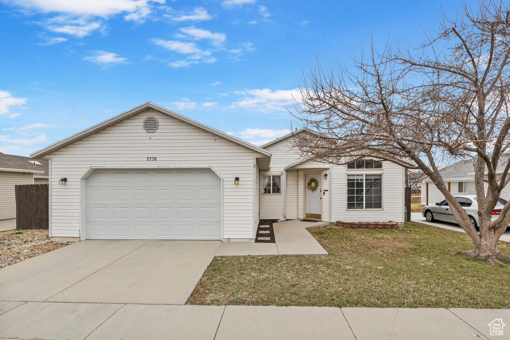 Single story home with a garage, concrete driveway, and a front yard