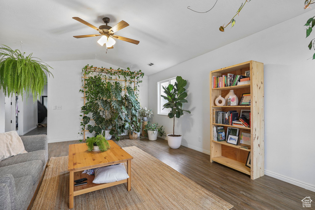 Living room with visible vents, ceiling fan, vaulted ceiling, wood finished floors, and baseboards